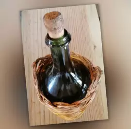 Vecchio bottiglione in vetro con cesto intrecciato